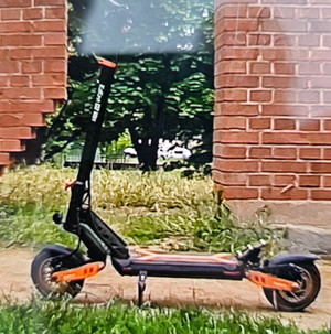 Zdjęcie przedstawia czarną hulajnogę elektryczną.