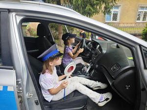 Zdjęcie przedstawia dzieci przy radiowozie.