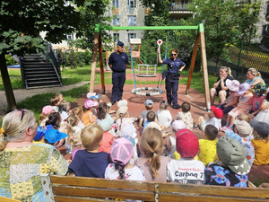 Zdjęcie przedstawia policjantów stojących przed dziećmi.