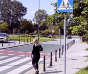 Zdjęcie przedstawia kobietę przechodzącą przez przejście dla pieszych.
