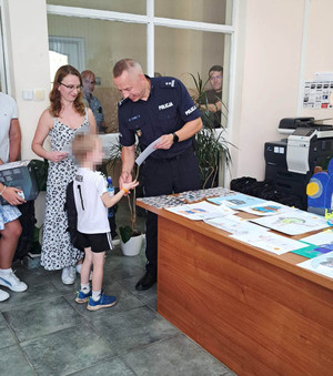 Zdjęcie przedstawia wręczenie dyplomu dziecku.