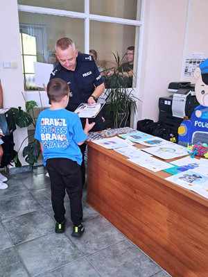 Zdjęcie przedstawia wręczenie dyplomu dziecku.