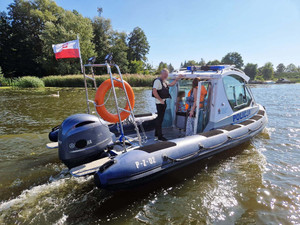 Zdjęcie przedstawia osoby płynące policyjną motorówką.