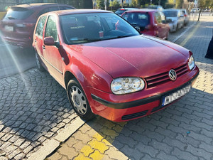 Zdjęcie przedstawia czerwonego volkswagena zaparkowanego na ulicy.