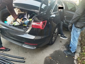 Policjanci przeszukują samochód mężczyzny.