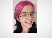 Zdjęcie przedstawia twarz młodej dziewczyny w okularach korekcyjnych i z włosami w odcieniu fioletu.