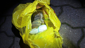 Zdjęcie przedstawia pieniądze w żółtej reklamówce.