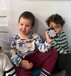 Zdjęcie przedstawia swoje dzieci siedzących pod ścianą. Jedno trzyma w dłoni policyjną legitymację.