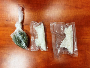 Zdjęcie przedstawia trzy foliowe opakowania ułożone na brązowym blacie biurka. W jednym z nich znajduje się susz roślinny, w dwóch pozostałych biała substancja.