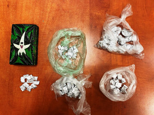 Zdjęcie przedstawia różne substancje opakowane i ułożone na brązowym blacie biurka.