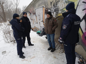 Zdjęcie przedstawia dzielnicowych i strażników miejskich stojących obok mężczyzny.