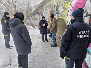 Zdjęcie przedstawia dzielnicowych i strażników miejskich stojących obok mężczyzny.