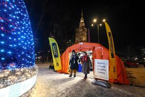 Zdjęcie przedstawia pomarańczowy namiot na tle śniegu.