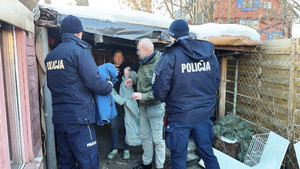 Zdjęcie przedstawia dwóch policjantów, którzy wręczają kurtki i termosy dwóm osobom.