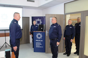 Zdjęcie przedstawia policjantów stojących przed sobą na sali.