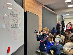 Zdjęcie przedstawia chłopca z aparatem.