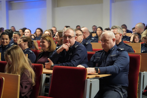 Zdjęcie przedstawia policjantów siedzących na widowni.