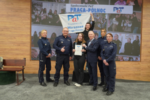 Zdjęcie przedstawia policjantów i mężczyzn oraz młodą kobietę pozujących do zdjęcia.