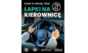 Zdjęcie przedstawia kolorowy plakat z rysunkiem rąk na kierownicy.