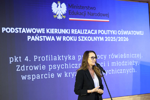 Zdjęcie przedstawia kobietę przed mikrofonem.