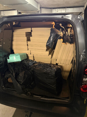 Zdjęcie przedstawia kartony ułożone w bagażniku samochodu.