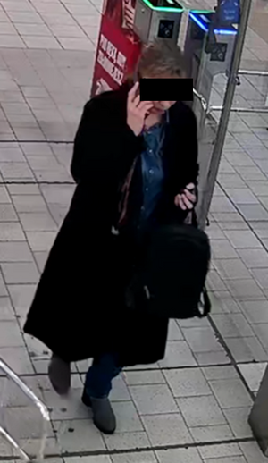 Zdjęcie przedstawia ubraną na ciemno kobietę która ma część twarzy zasłoniętą czarnym prostokątem.
