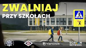 Zdjęcie przedstawia kolorowy plakat na którym widać dziecko idące przez przejście dla pieszych. Na plakacie widnieje napis:"Zdjęcia: Zwalniaj przy szkołach".