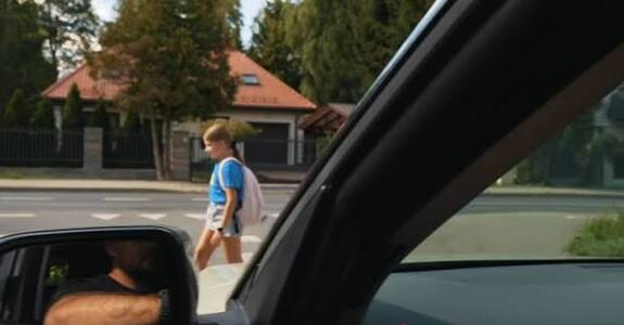 Zdjęcie przedstawia dziewczynkę idącą przez pasy.