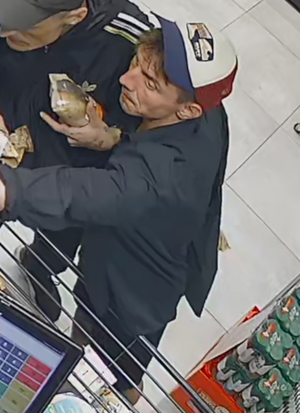 Zdjęcie przedstawia sylwetki dwóch mężczyzn stojących przy kasie.