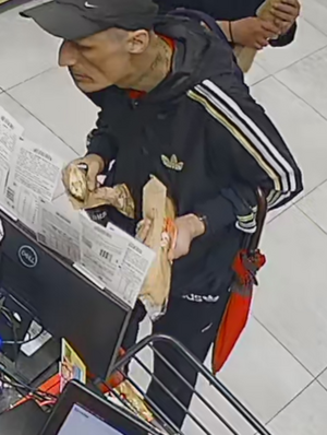 Zdjęcie przedstawia sylwetkę mężczyzny przebywającego w placówce handlowej.